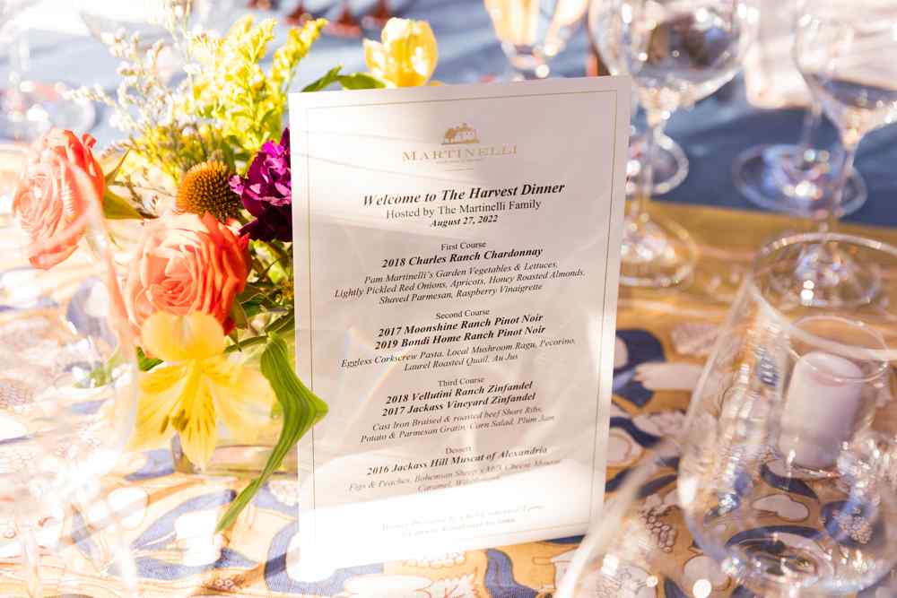 Dinner menu on table set with flowers and empty wine glasses